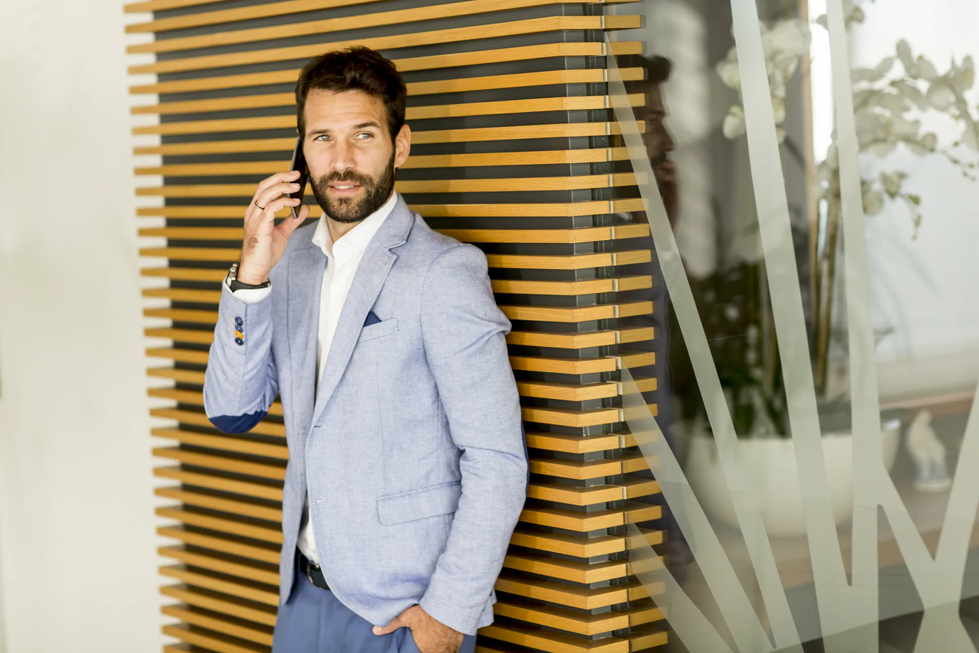 Profesional hablando por teléfono de pie en una oficina moderna