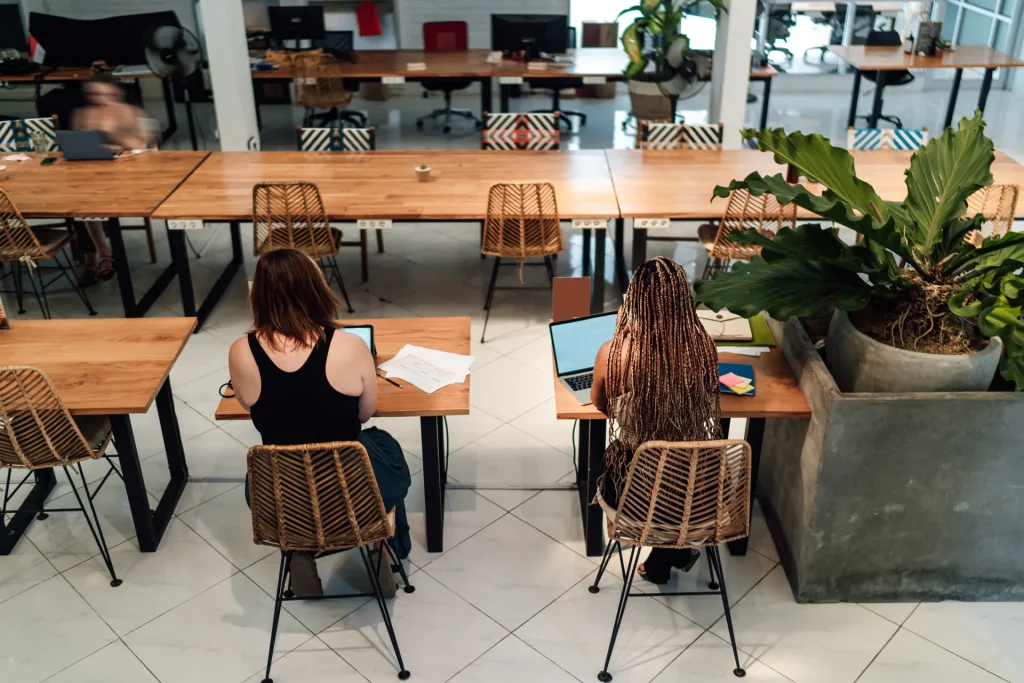 Mujeres trabajando con portátil en las mesas de un espacio de coworking