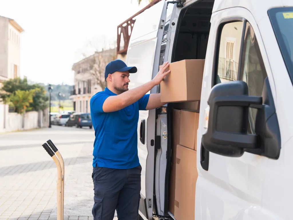 Repartidor descargando cajas de una furgoneta blanca