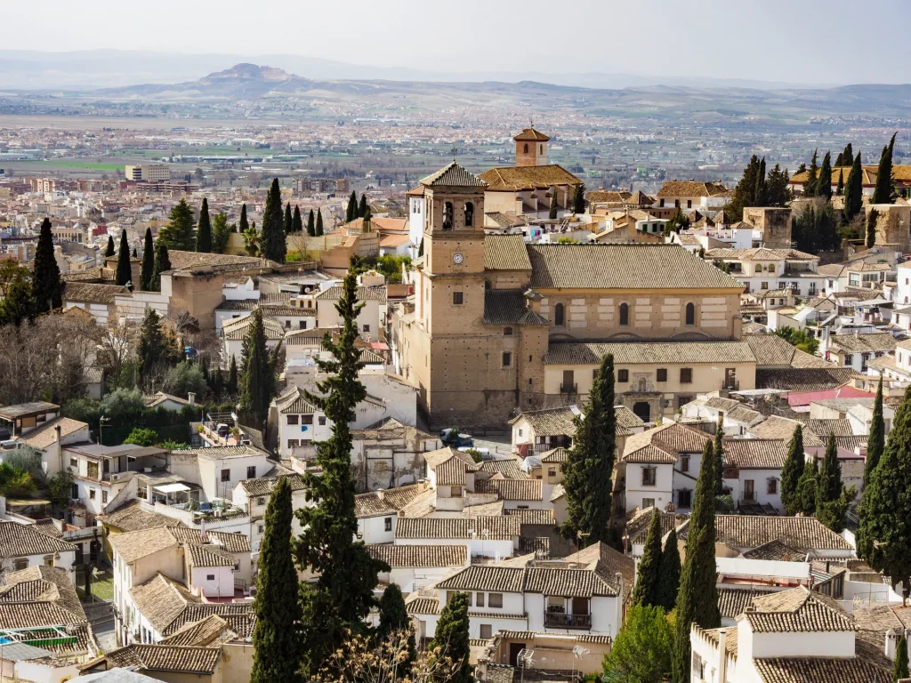 Barrio histórico de Granada con iglesias y casas blancas entre cipreses