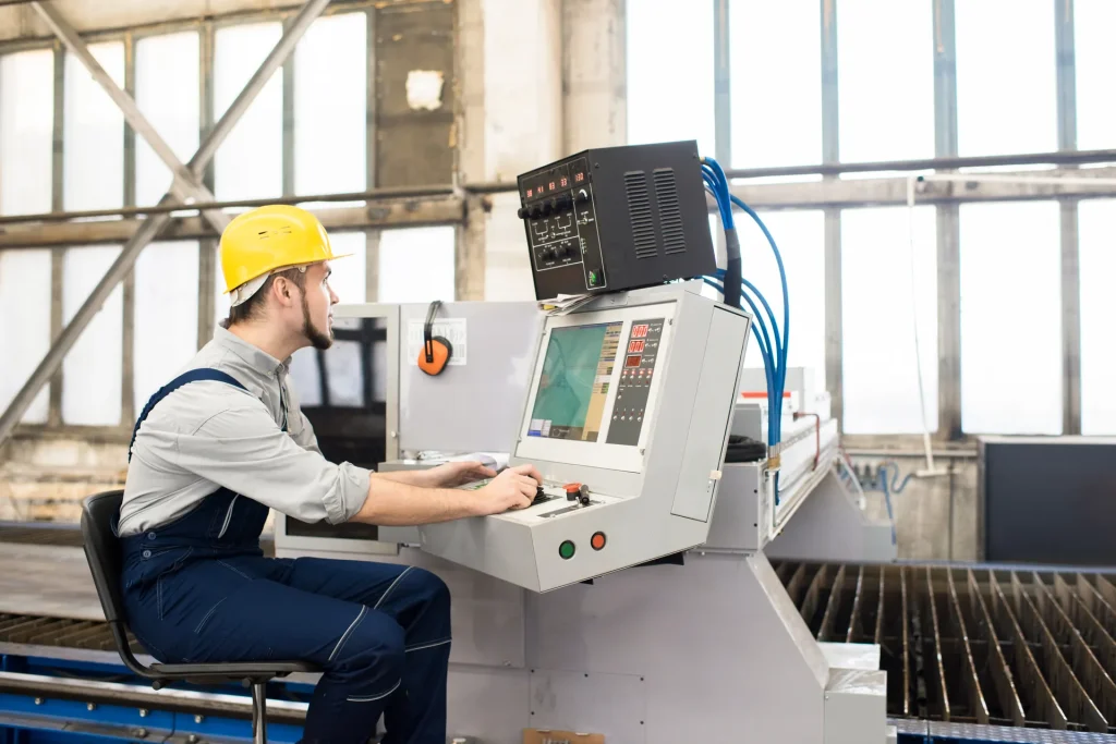 Operario controlando una máquina industrial desde su panel de mando