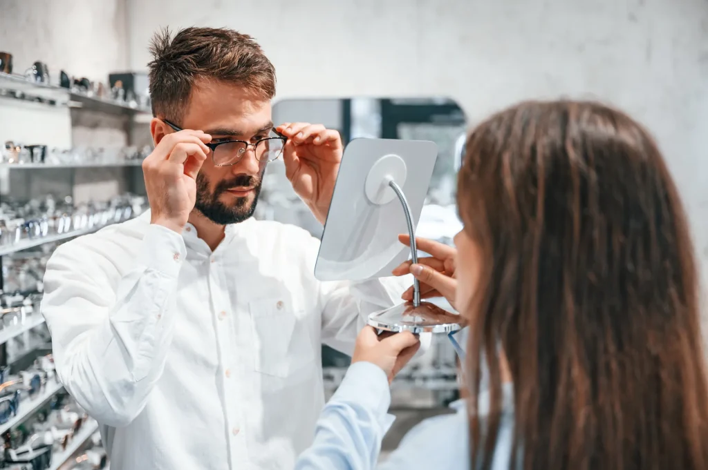 Cliente probándose unas gafas frente al espejo de una óptica