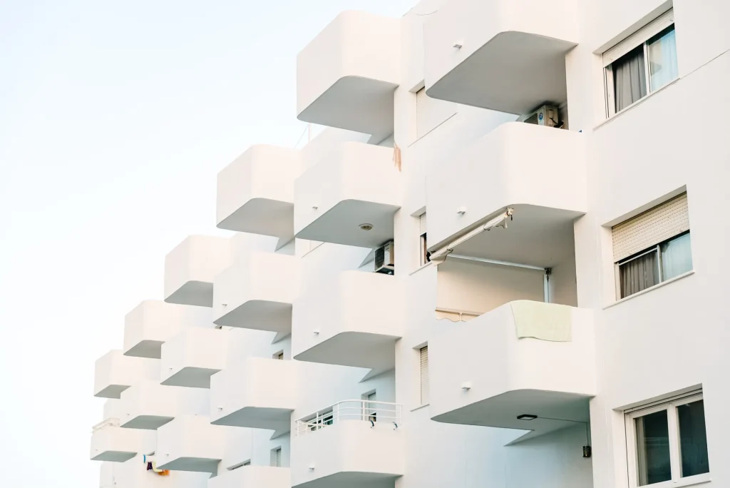 Fachada blanca de un edificio de viviendas con balcones