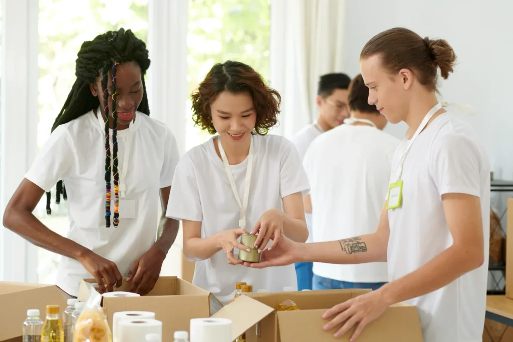 Voluntarios preparando cajas de alimentos en una actividad solidaria