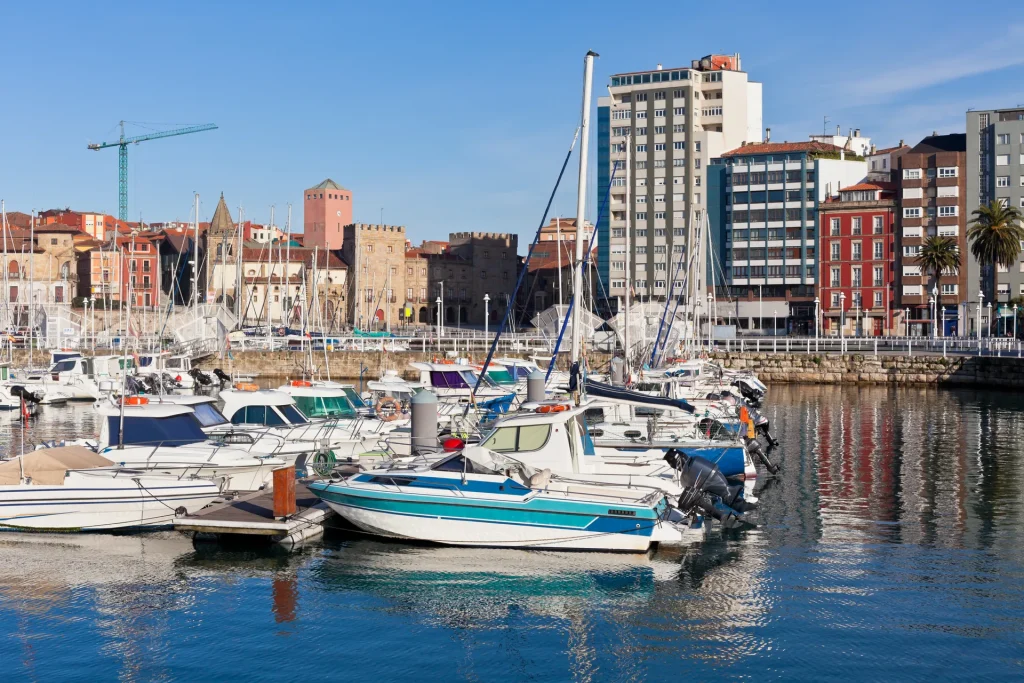 Puerto deportivo de Gijón con veleros frente a los edificios del casco antiguo