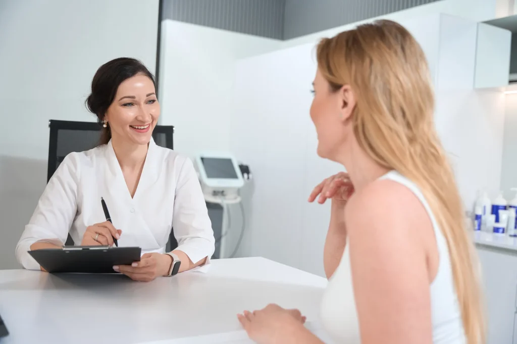 Doctora sonriente atendiendo a una paciente en su consulta