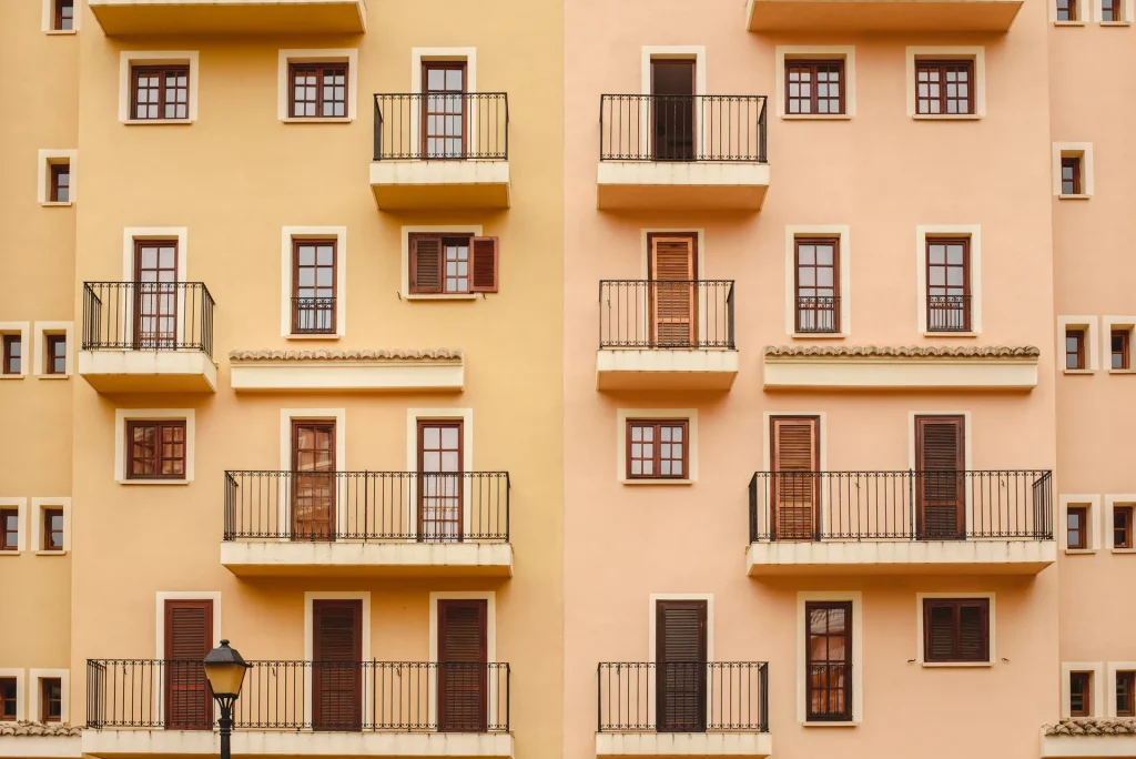 Fachada de un bloque de viviendas color albaricoque con balcones